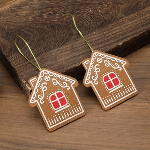 Detailed close-up of felt gingerbread house ornaments with gold strings on wooden background