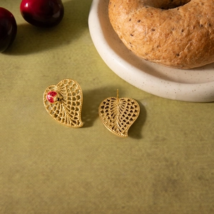 Detailed view of leaf earrings with hollow gold texture and small ladybug decor