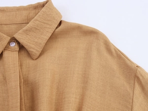 Close-up of khaki elegant shirt showing detailed twill texture and white button detail