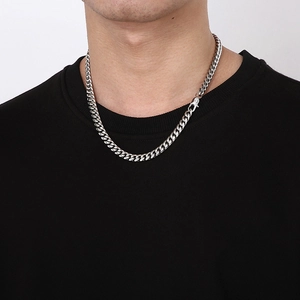 Close-up of a stylish silver Cuban link chain necklace worn on a black sweatshirt