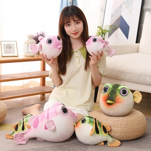 Peluches de poisson-globe en plusieurs tailles et couleurs dans un décor chaleureux