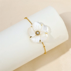 Macro shot of 18k gold plated bracelet with shell flower charm and central crystal