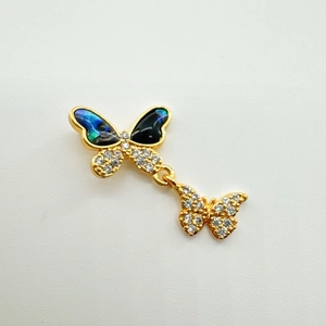 Détail macro du pendentif papillon en or 18 carats avec nacre irisée et zircons