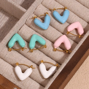 Macro shot of colorful enamel heart earrings in gold finish displayed in a jewelry box
