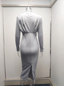 Detail view of back slit design on a slim-fit grey long-sleeve knitted dress