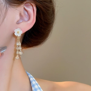 Detailed view of floral tassel earrings with white petals and crystal water drops