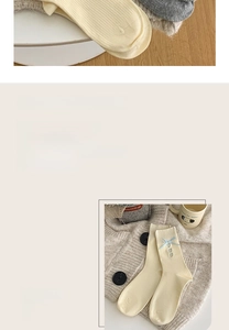 Details der Rippstrick-Baumwollsocken mit blauen Schleifen und Herz-Stickerei-Verzierung