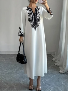 Abito lungo bianco con scollo a V e ricami etnici neri su scollatura e maniche lunghe