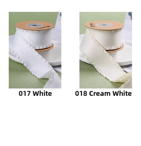 Détail du ruban à volants blanc et crème sur bobines pour la couture DIY