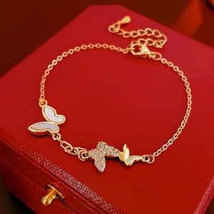 Gold plated butterfly bracelet with mother of pearl and cubic zirconia on red jewelry box