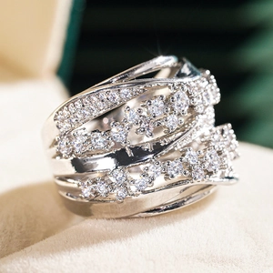 Macro view of wide crisscross ring featuring multiple layers of pavé set cubic zirconia