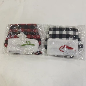Macro shot of two festive plaid Christmas hats in clear plastic packaging