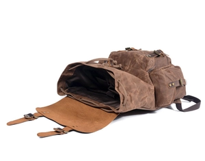 Detail view of vintage oil wax canvas backpack showing interior space and leather straps