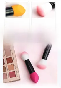 Detailed view of dual-ended makeup brush with soft pink bristles and yellow sponge tip