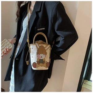 Detailed view of mini leather bucket bag featuring a cute 3D bunny patch and monogram pattern