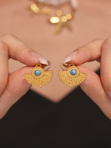 Macro detail of fan-shaped turquoise stud earrings with 18k gold-plated hammered texture