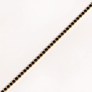 Close-up of gold chain bracelet with single row of square black zircon claw setting