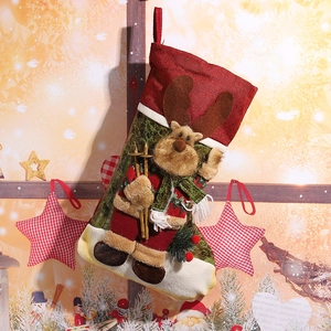 Festive burlap Christmas stocking with plush 3D reindeer holding skis in holiday scene.