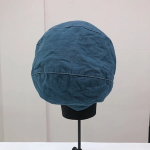 Dettaglio del basco blu scuro con cuciture bianche e trama in tessuto di lino