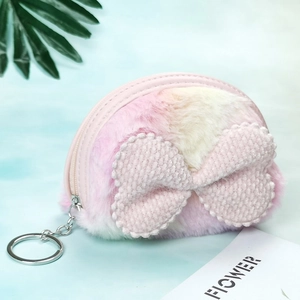 Detail view of plush pink gradient coin purse with soft bow and silver keychain hook