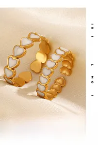 Detail of 18K gold plated heart ring with white inlay on elegant silk background