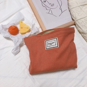 Orange houndstooth canvas pouch with Time to Party label on a cozy lifestyle background