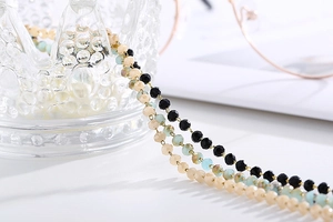 Macro detail of multi-color faceted beaded eyewear chain with blue and black beads