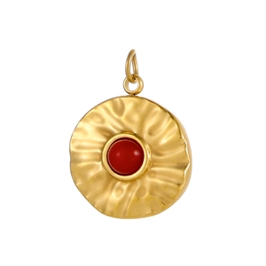 Macro view of gold hammered texture pendant with a vibrant red round gemstone
