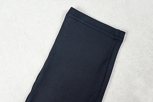 Close-up of premium black fabric with neat stitching on backless sexy jumpsuit cuffs