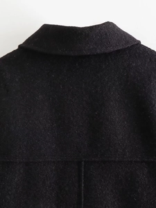 Detail of clean stitching and high-quality wool texture on black coat collar and back