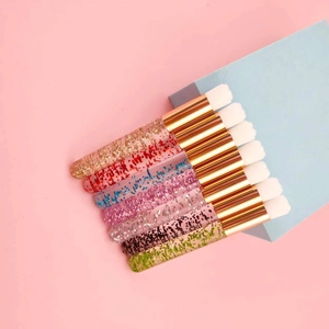 Detail of 7 glitter handle cleansing brushes with gold ferrule and white soft bristle
