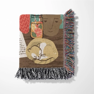 Detailed macro of woven artistic blanket featuring sleeping cat and soft fringe edges
