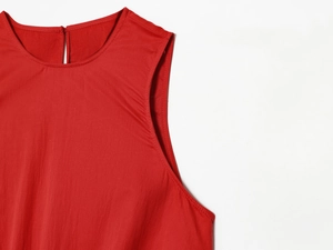 Détail du haut rouge sans manches avec col rond montrant les coutures et la fente au dos