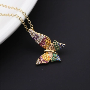Macro shot of gold butterfly pendant with colorful gemstones and creative hollow design