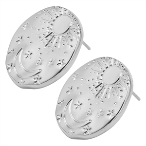 Macro detail of oval stainless steel stud earrings featuring sun, moon, and star relief design