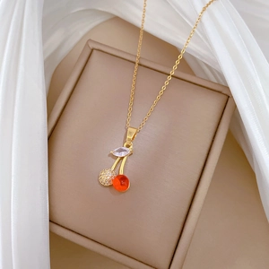 Detail of gold cherry necklace with red gems and sparkling zircons on jewelry box