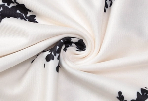 Vue macro d'un tissu en mousseline blanche avec imprimé floral noir et texture fine