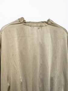 Detail view of the beige satin jacket back featuring a pleated collar and silky texture