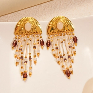 Detail of vintage gold earrings with white oval stones and dark brown beaded tassels