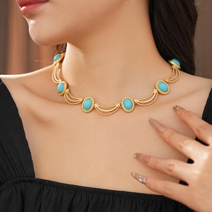 Close-up of vintage golden necklace with oval turquoise gemstone and crescent links