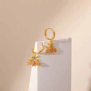 Macro shot of 18K gold plated hoop earrings with colorful zircon paved honey bee charms