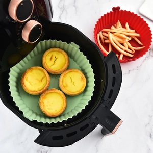 Green and red heat-resistant silicone air fryer liners with french fries and egg tarts
