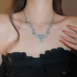 Close-up of elegant leaf and flower pendant necklace set with silver rhinestones