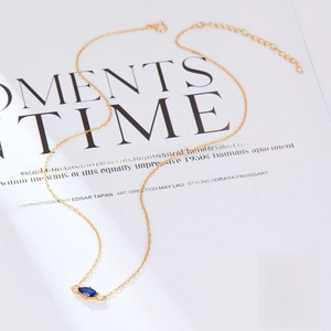 Detail of S925 sterling silver necklace with blue marquise zircon on a magazine