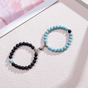 Détail de bracelets de couple avec aimants en cœur et perles en pierre naturelle mate