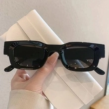 Close-up of black retro rectangular sunglasses with thick frames and premium finish