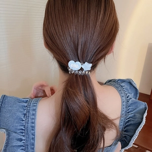 Vue détaillée d'un chouchou spirale bleu avec pendentifs cœur et étoile sur cheveux