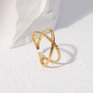 Detail of gold layered crossover ring featuring smooth and twisted rope texture design