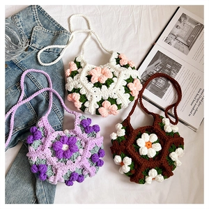 Detail of handmade crochet flower crossbody bags with pearl button and woven straps