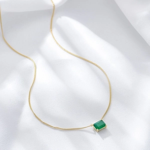 Elegant S925 silver necklace with a green emerald square pendant on white silk fabric